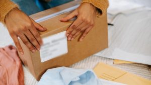 Online seller sealing a parcel for international shipping to Europe.